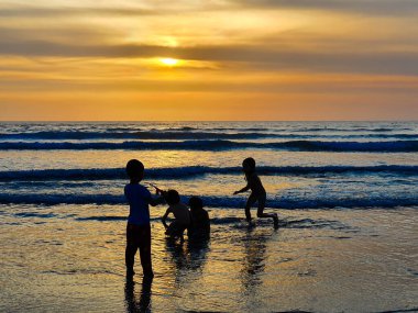 Kuta Sahili 'nde oynayan çocuklar, akşamları bali