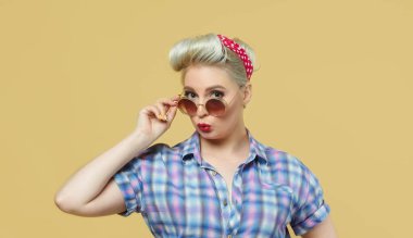 Sarı arka planda poz veren güzel sarışın.