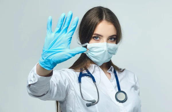 Covid19, koronavirüs, bir sağlık ve doktor konsepti. Dur hareketi gösteren bir kadın doktorun portresi! Virüs enfeksiyonunu önlemek için tıbbi maske takıyor.