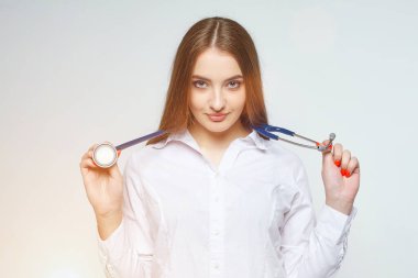 Beyaz arka planda steteskobu olan genç bir doktorun portresi.