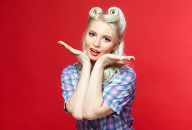 Büyük şekerli güzel sarışın, kırmızı arka planda poz veriyor.