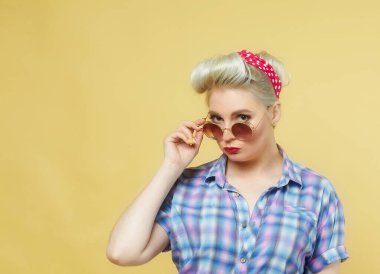 Sarı arka planda poz veren güzel sarışın.