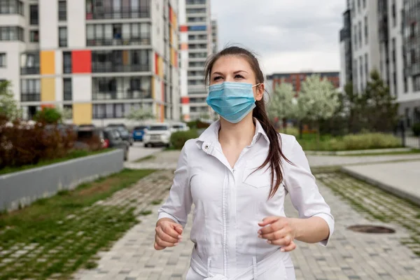 girl in a medical mask on the street. girl in a medical mask in the city. girl 20-29 years old
