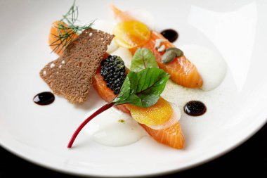 Siyah havyarlı somon aperatifi, turp diski, balsamik sos..