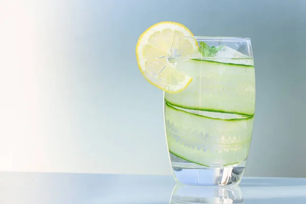Mavi arka planda limonlu bir bardak su, kopyalama alanı. 