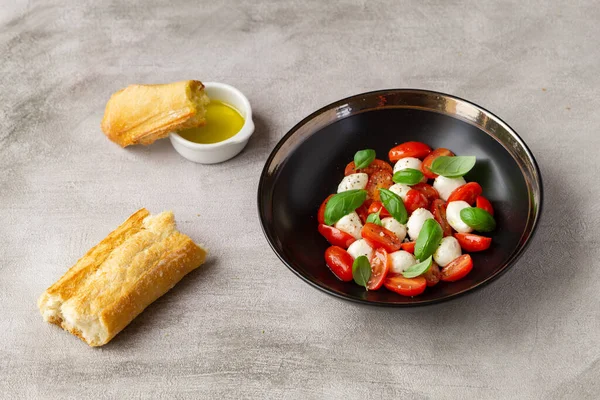 Mozzarella, domates ve fesleğenli ekmekli Caprese salatası.