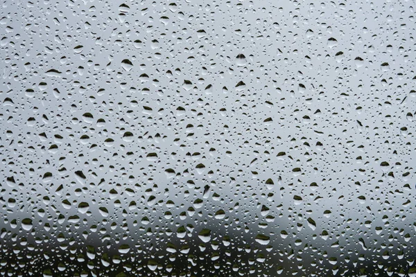 Rain drops on window with grey textured background. — Stock Photo, Image
