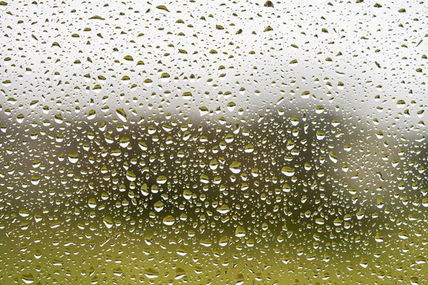 Падіння дощу на вікні з сірим текстурованим фоном . — стокове фото