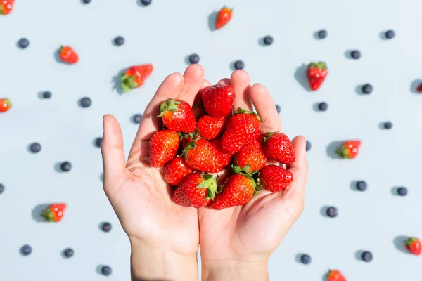 Strawberries in hands. Close up. Fruit pattern. Top view