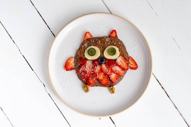 Beyaz arka planda izole edilmiş bir tabakta çocuklar için yaratıcı baykuş gözlemesi.