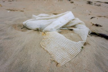 Deniz fırtınasından sonra kum üzerinde plastik torba. Ekolojik sorun 