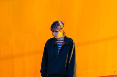 Alternatif kız sarı arka planda, sakızlı üzgün.