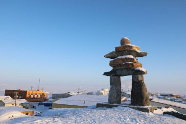 Tek Inuksuk ya da Inukshuk, Kanada 'nın Nunavut, Rankin Körfezi' ndeki tepenin tepesinde karla kaplıdır.