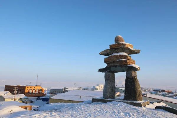 Tek Inuksuk ya da Inukshuk, Kanada 'nın Nunavut, Rankin Körfezi' ndeki tepenin tepesinde karla kaplıdır.
