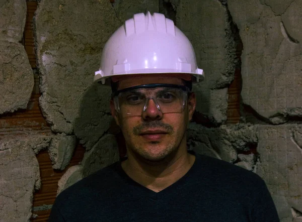 Kasklı ve koruyucu gözlüklü bir adam, inşaat memuru.