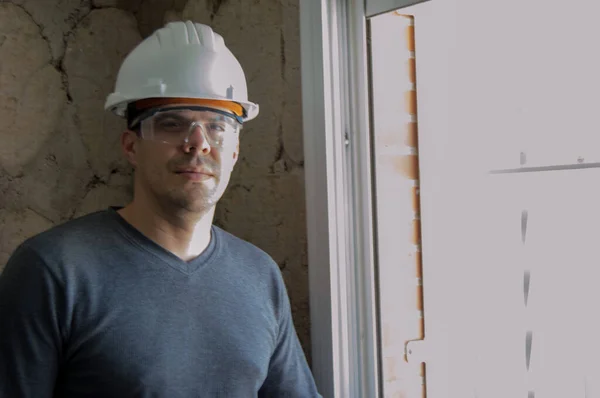 Man with helmet and protective glasses, construction officer