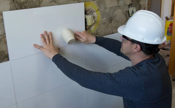 Man Tegelwerk Een Muur Met Tegels Witte Foelie Stockafbeelding