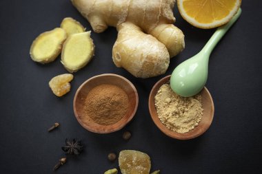 Siyah arka planda zencefil kökü ve baharatlar. Sağlıklı gıda konsepti, virüslerden korunma, koronavirüs karantinasında artan bağışıklık, süper yiyecekler. Seçici odak.