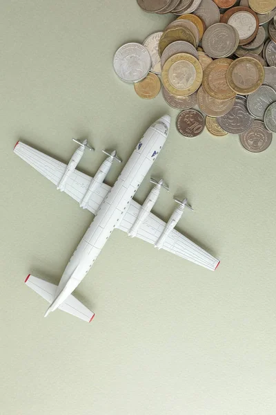 toy plane and money-coins on a green background, the concept of closing borders around the world due to coronavirus, financial losses of airlines and tour operators.