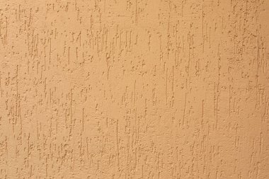 Duvardaki alçı dokusu; bej renklerle boyanmış düz pastel arkaplan.