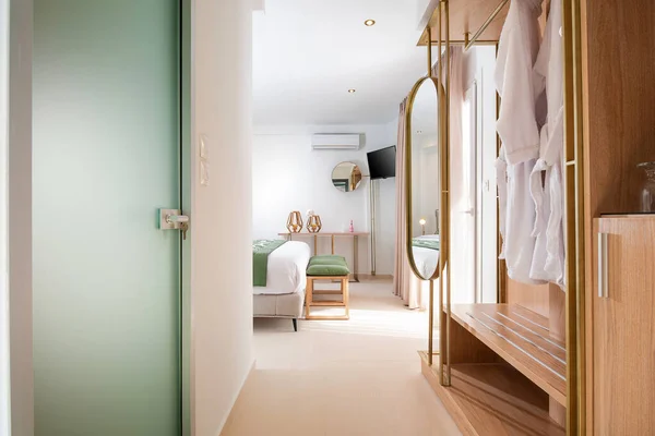 Apartment entrance hallway with bathroom glass door and wooden wardrobe cabinet. front view of modern spa hotel interior room