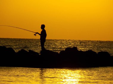 Gün batımında balık tutmak, büyük okyanusta tuz.