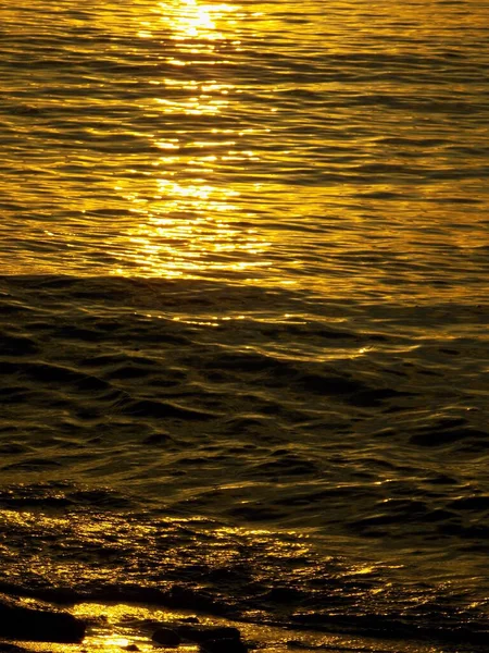 Reflection of the light of the morning sun in the waves