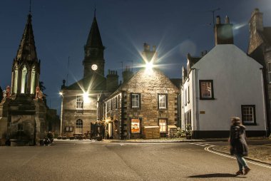 Falkland, İskoçya, İngiltere; 25 Nisan 2018: Outlander dizisinde Inverness 'i temsil eden şehrin eski karesi. Buradan geçen bir bayan..