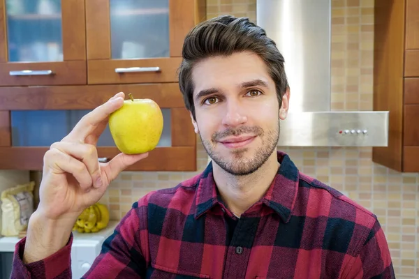 Jovem Atraente Chef Masculino Alegre Mostrando Uma Maçã Cozinha Vestindo — Fotografia de Stock