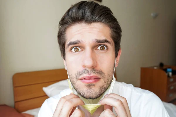 Retrato Jovem Com Uma Emoção Confusa Puxando Uma Máscara Facial — Fotografia de Stock