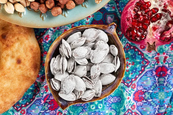 Traditional Azerbaijan sweet cuisine of holiday Nowruz: apricot bones fried with salt, assortment of nuts and dry fruits