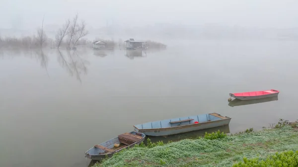 停泊在平静的河边的老旧生锈的渔船上 而渔夫的茅屋则在大雾中的江岛前面 朦胧的秋色笼罩着浓雾 — 图库照片