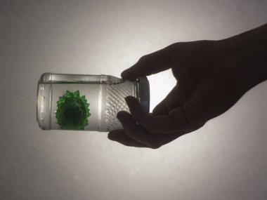 Elinde koronavirüs olan bir kavanoz.