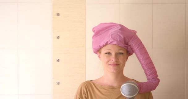 Donna Bionda Bagno Asciuga Capelli Con Asciugacapelli Con Bigodini Sorridenti Video Stock