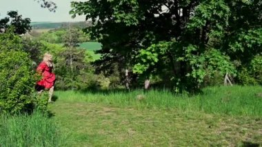 Kırmızı tarihi kostümlü sarışın kadın. Eski moda. Gizli pencereden bakıyor.