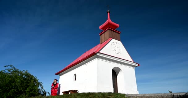 身穿红色历史维多利亚风格服装 头戴帽子从教堂走出来的可悲女人 小白教堂 — 图库视频影像