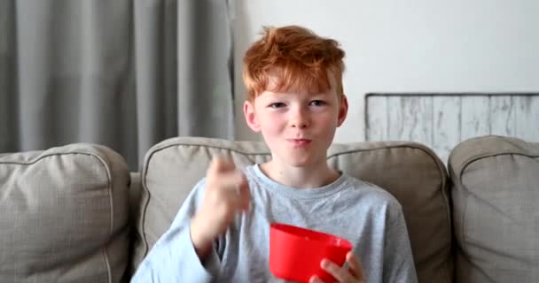 Kleine Jongen Met Rood Haar Zittend Woonkamer Ontbijten Cornflakes Ochtend — Stockvideo