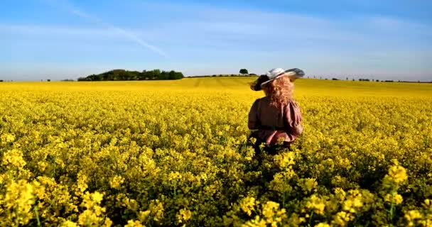 Yağ Çekirdeği Tarlasında Duran Büyük Şapkalı Çiçekli Sarışın Kadın — Stok video