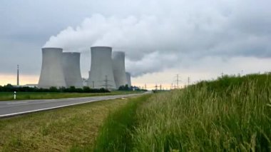 Yeşil doğa çayırlarında tüten dört bacası olan nükleer enerji santrali. Zaman Ayarı videosu. 