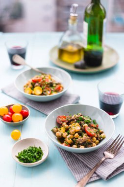 Ev yapımı nohut salatası, kızarmış biftek ve kırmızı şaraplı vişneli domates ve müktesebat..