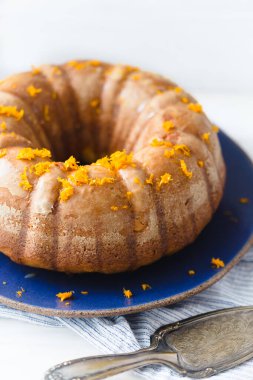 Mavi seramik ve çizgili peçeteli turuncu kek..