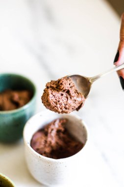 Küçük fincanlar ve mermer arka planda çikolatalı mus..