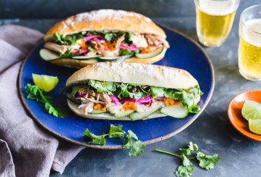 Turşulu domuz eti, soğan, salatalık, havuç ve sriracha soslu gri bir yüzey..