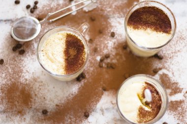 Tiramisu, üzerinde kakao tozu olan bir bardakta mermer ve gri arka plan manzaralı..