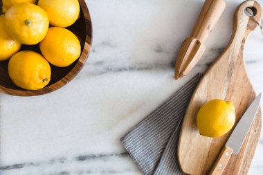 Mermer yüzeyinde mutfak aletleri olan taze limonlar..
