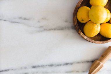 Mermer yüzeyinde mutfak aletleri olan taze limonlar..