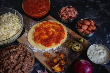 Fırınsız ev yapımı pizza. Sosis, peynir, jambon. Et, olgun, domates. Pizza yapmak. Küçük Pizzacı