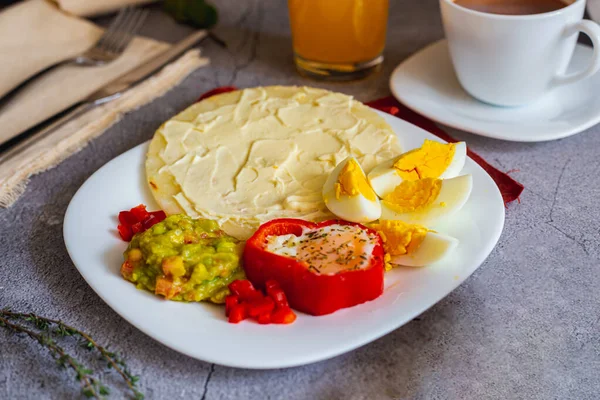 Yumurta, jambon ve krem peynirli Arepa Paisa. Bir eskort olarak Guacamole (Kolombiya kahvaltısı)