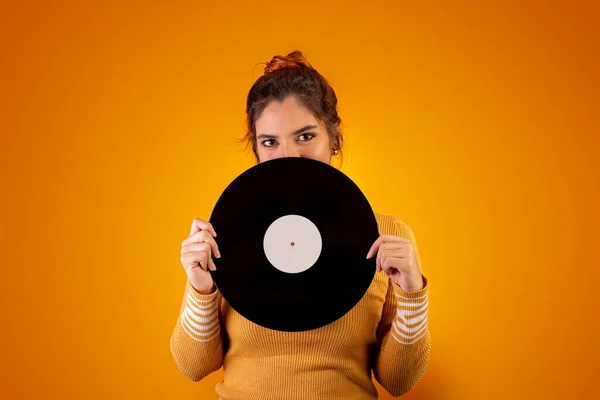 Sarı arka planda müzik diski olan kadın