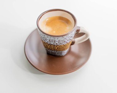 Kahverengi bir bardakta espresso ve sabah beyaz bir parmak izi.